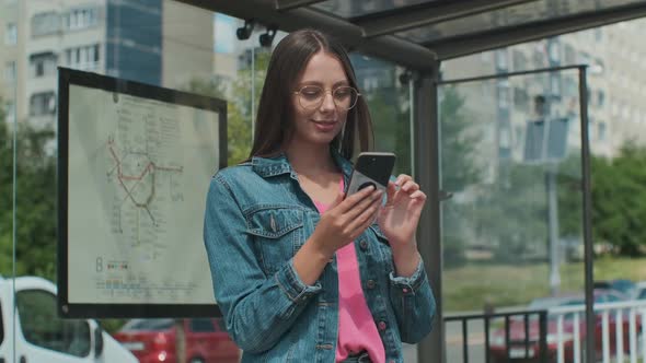 Young Stylish Woman Waiting for the Public Transport While Standing at the Modern Tram Station