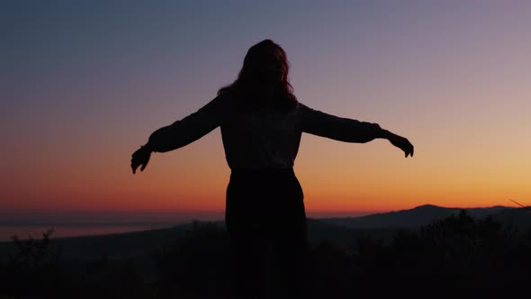 Silhouette of Girl Dancing with Open Arms