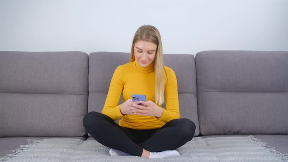 Cheerful white female using trendy blue smartphone for communication online on social media app