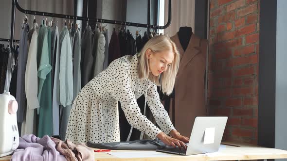 Beautiful Fashion Designer Is Looking at Laptop and Smile