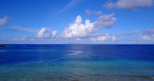 Wide aerial tourism shot of a white sand paradise beach and blue sea background in high resolution 4