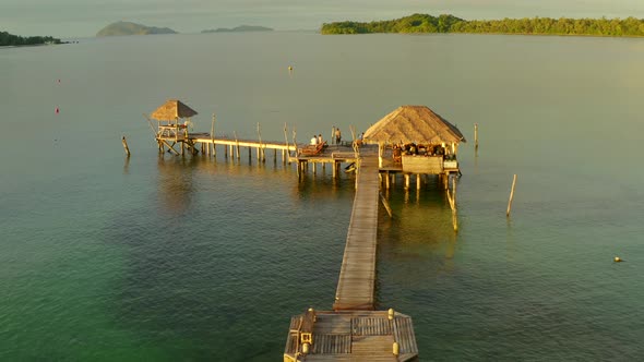 Sunset Over Wooden Beach Bar in Sea and Hut on Pier in Koh Mak Island Trat Thailand