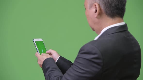 Mature Japanese Businessman Showing Phone To Camera