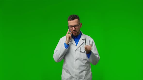 Portrait of Male Professional Doctor with Stethoscope in Medical Mask Stands Isolated on Green