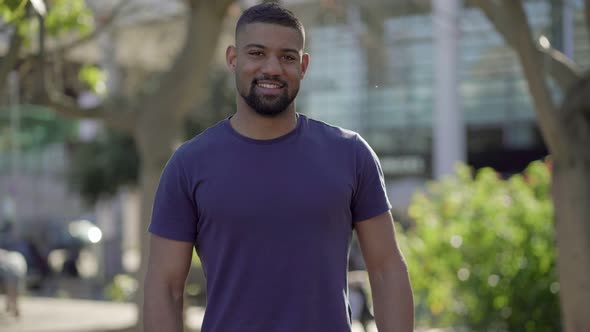 Medium Shot of Young Man in Park Looking at Camera, Smiling