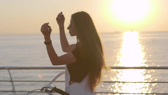 Young Attractive Woman with Long Hair is Having a Good Time at Sea