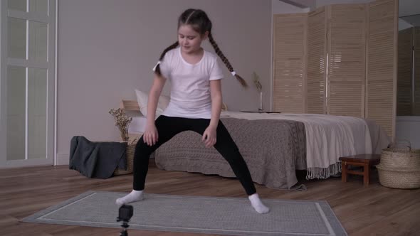 Girl Child Broadcasts an Online Course and Writes a Vlog About Gymnastics at Home