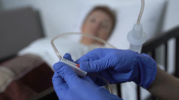 Hospital Worker Turning-On Drop Counter and Supporting Female Patient, Injection