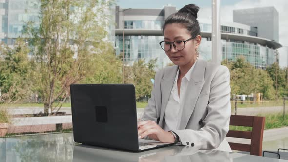 Businesswoman Working on Laptop in Outdoor Cafe