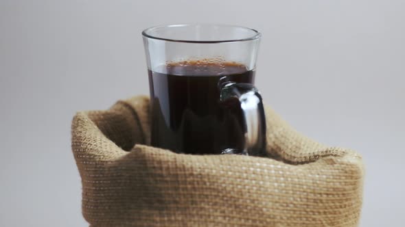 The Invigorating Coffee in a Glass Mug Stands in a Burlap Bag Swirls in Place