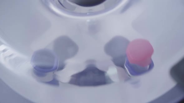 Female Hand Putting Blood Sample in Centrifuge and Turning on Equipment. Extreme Close-up of