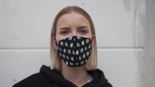 Portrait of Young Woman With Face Mask Looking at Camera, Close Up Slow Motion. Covid-19 Virus Outbr