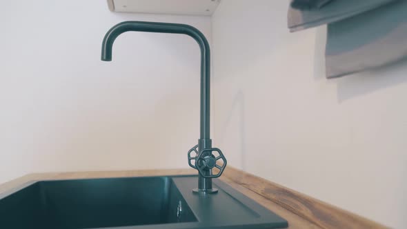 Motion Past Black Stylish Faucet and Sink at Wooden Counter