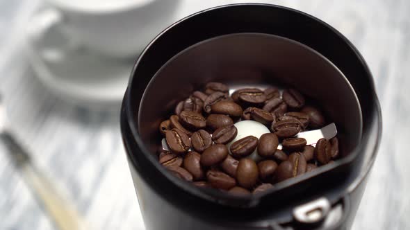 Filling the electric coffee grinder with coffee beans 