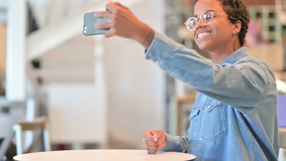 Cheerful African Woman Taking Selfie on Smartphone at Cafe 