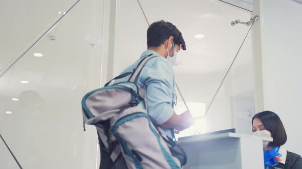 Caucasian male passenger handing phone to airline staff for scanning at check in counter in airport