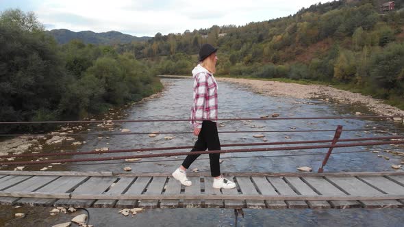 Aerial View of Tourist Woman Walk on Wooden Bridge Across Mountain River