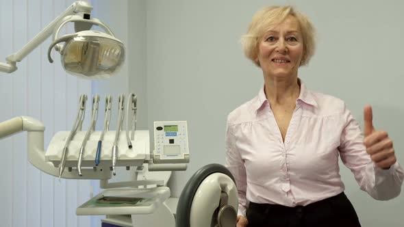 Senior Woman Shows Her Thumb Up at the Dentist Office