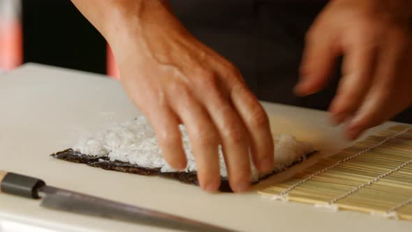 Hands of Man Preparing Sushi.