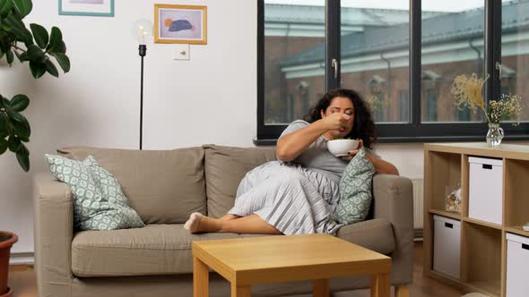 Smiling Young Woman Eating Vegetable Salad at Home