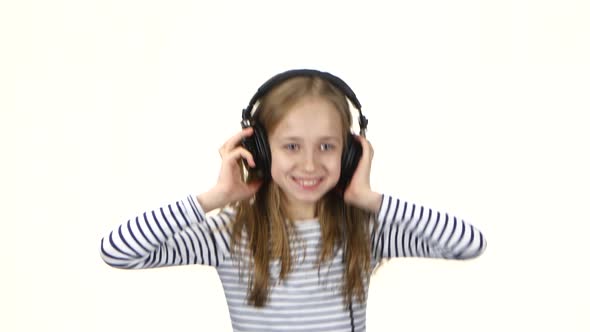 Girl Listens Music on Headphones and Showing Tongue, White Background