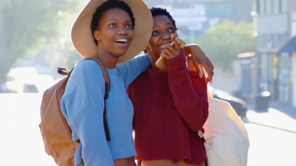 Front view of African American twin sisters standing on street in the city 4k