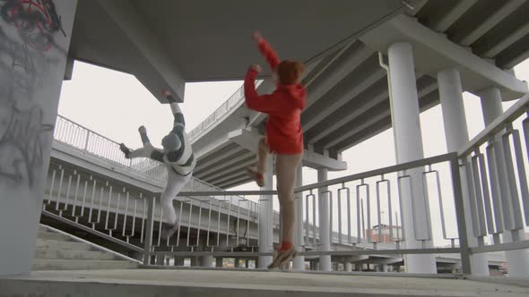 Two Parkourists Doing Side Flips Synchronically