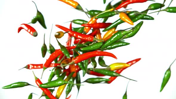 Super Slow Motion Shot of Mixed Chilli Side Colision Isolated on White Background at 1000Fps