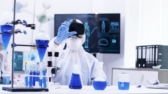 Young Female Scientist in Chemistry Lab with Virtual Reality Headset Zooming Out alt