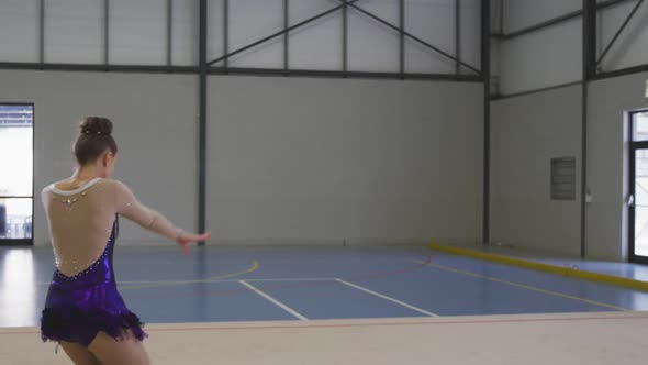 Female gymnast performing at sports hall