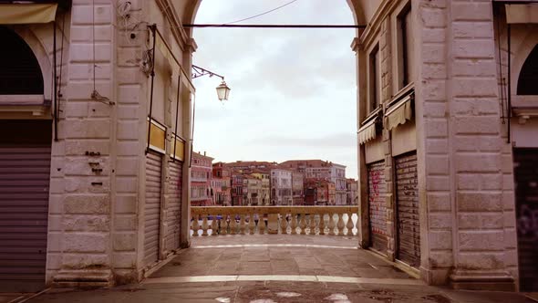 Stone Arch on Bridge Over Grand Canal with Small Gondolas