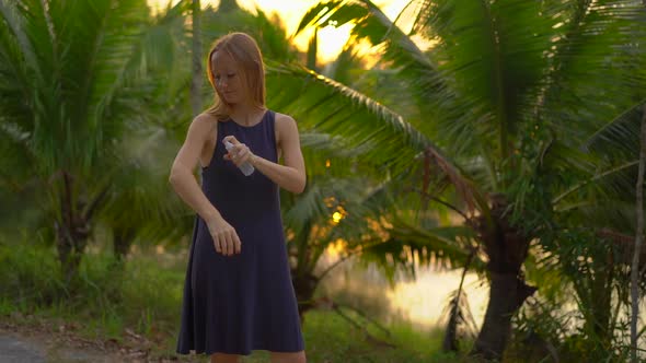 Superslowmotion Shot of a Beautiful Young Woman Applying an Antimosquito Repellent Spray on Her Skin