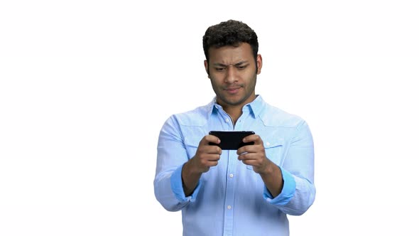 Young Concentrated Man Playing Game on Smartphone