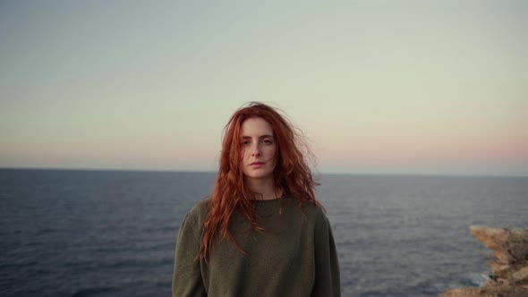 Redheaded woman on viewpoint at sunrise, Ibiza