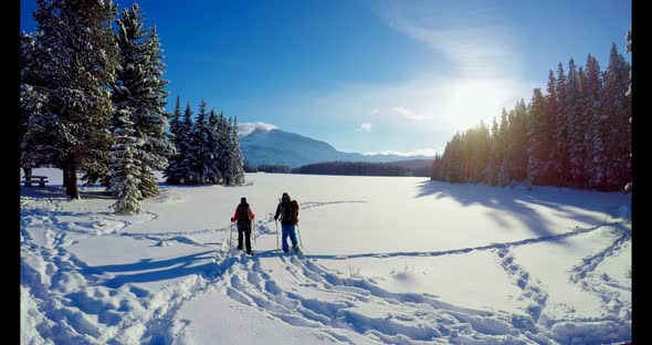 Skier Couple Walking on Snowy Landscape 4k