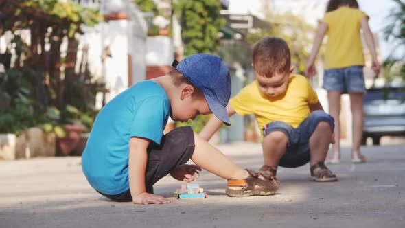 Funny Little Children Like To Play a Fun Game Together, Making Drawings with Colored Crayons