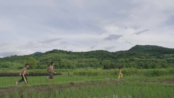 Rural Boys Running With Kite In The Field