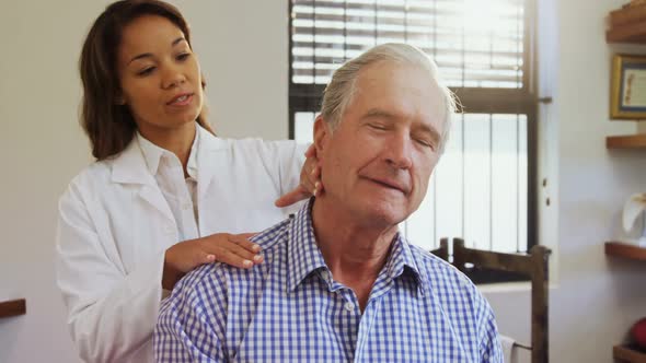 Senior man receiving neck massage from physiotherapist