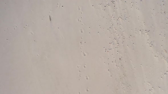 AERIAL: Top View of Sandy Beach with Footprints in the Sand