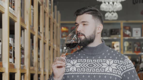Handsome Man Tasting Red Wine at Wine Supermarket