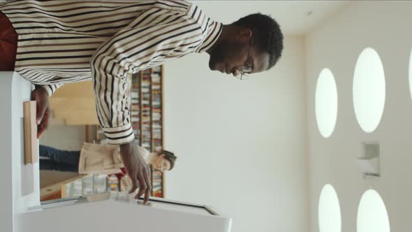 African Man Using Interactive Display in Modern Library