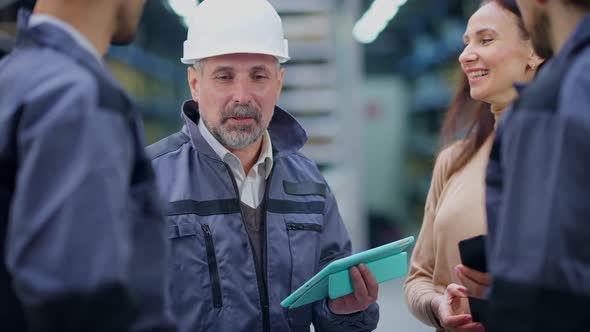 Portrait of Positive Confident Experienced Professional Foreman in Hard Hat Instructing Employees in