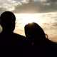 Silhouettes of a Couple of Young People at Sunset. A Woman Puts Her Head Gently on Her Man's - VideoHive Item for Sale