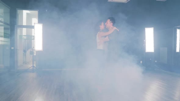 A Couple Dances in a Dance Studio Filled with Smoke