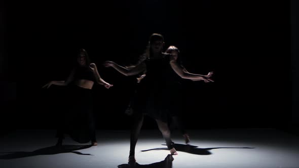 Contemporary Dance Moves of Three Dancers on Black, Shadow