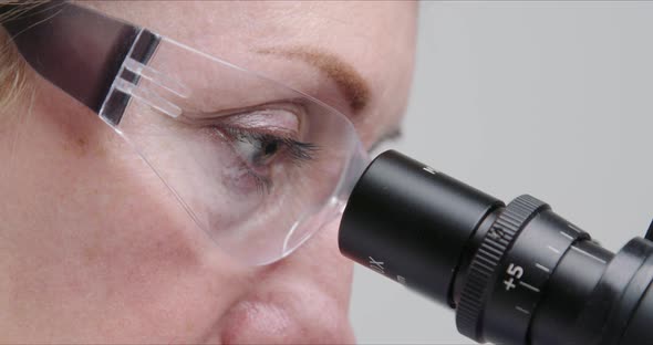 Woman Scientist Using Microscope in a Laboratory.