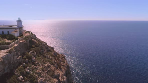 Lighthouse on rocky seashore with curved road