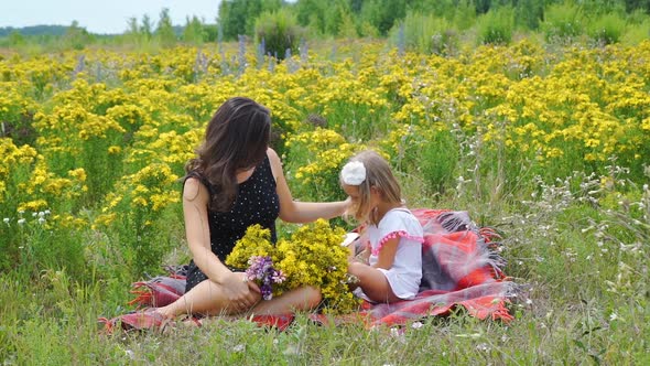 Woman with Daughter Relaxing in a Summer Field