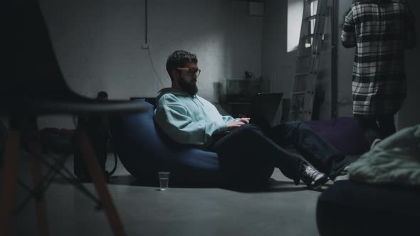 Man Using Laptop in a Bomb Shelter