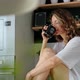 Young pretty woman drinks coffee sitting at her kitchen at home - VideoHive Item for Sale